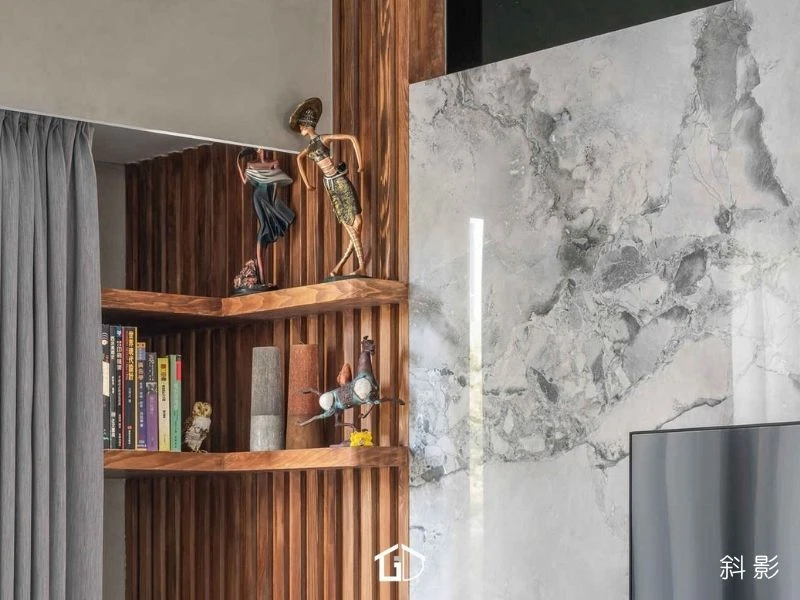 電視牆立面美學：灰色幾何格柵與石材拼接，營造空間視覺延伸感